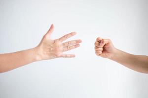 Paper symbol and rock symbol in playing rock paper scissors game on white background. photo