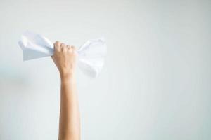 dorso de la mano que aplasta el papel blanco y lo levanta sobre fondo blanco con espacio de copia. foto