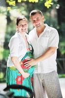 Happy pregnant couple at beautiful sunny day in park photo