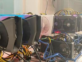 Row of bitcoin miners set up on the wired shelfs. Device for mining crypto currency. Mining cryptocurrency. Bitcoin farm. Machines for mining cryptocurrency bitcoin. Electronic device at day. photo