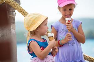 little girls eating ice cream by the sea photo
