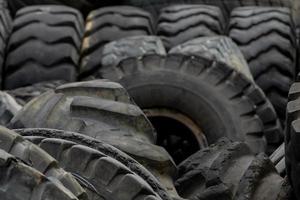 Closeup used truck tires. Old tyres waste for recycle or for landfill. Black rubber tire of truck. Pile of used tires at recycling yard. Material for landfill. Recycled tires. disposal waste tires. photo