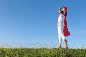 beautiful woman with red scarf on meadow photo