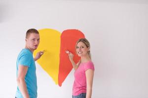 couple are painting a heart on the wall photo