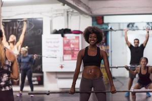 black woman lifting empty bar photo