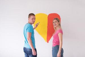 pareja está pintando un corazón en la pared foto