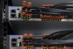 primer plano de la sala del servidor de red en el concentrador o conmutador de fibra óptica para comunicaciones digitales e Internet en la supercomputadora del centro de datos de negocios corporativos de mainframe. foto