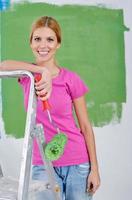 happy smiling woman painting interior of house photo