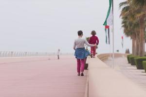 mother and cute little girl on the promenade by the sea photo