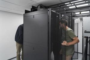 Technicians team updating hardware inspecting system performance in super computer server room or cryptocurrency mining farm. photo