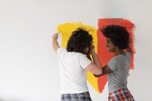 multiethnic couple painting interior wall photo