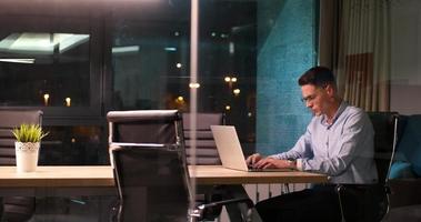 hombre trabajando en una laptop en una oficina oscura foto