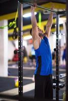 hombre haciendo pull ups en la barra horizontal foto