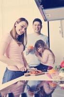 familia joven feliz en la cocina foto