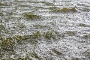 Heavy rain storm and waves water texture Oste river Germany. photo