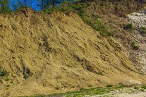 Excavated sand mountains and rubble piles quarry lake dredging pond. photo