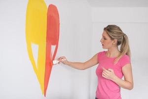 woman painting a heart on the wall photo