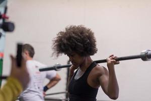 black woman lifting empty bar photo