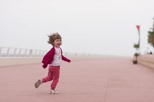 linda niña en el paseo marítimo junto al mar foto