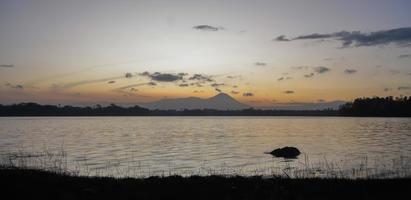 Panoramic view of sunrise with a special orange effect against the background of mountains and lake photo