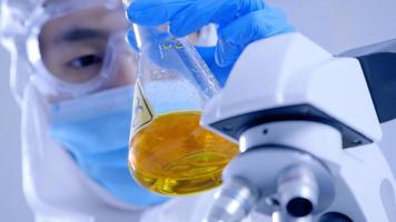 Scientist in PPE suite doing some research checking a liquid in a test tube at laboratory. photo