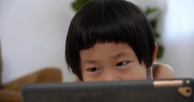 Cute little boy using tablet computer at home. photo