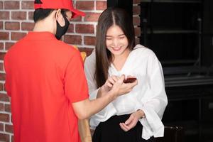 Happy woman recieving food from food deliveryman photo