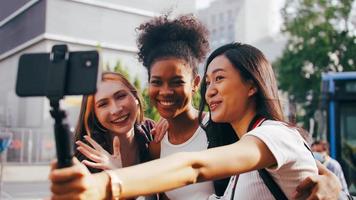 A group of multi-ethnic female friends enjoying the city tour. Young tourists having fun taking pictures together. photo
