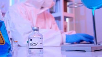 Scientist in PPE suit conducts research on the COVID 19 vaccine at a laboratory. photo