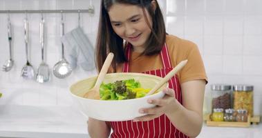 joven mujer asiática cocinando en la cocina en casa. foto