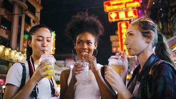 grupos de amigas multiétnicas disfrutan de una noche en yaowarat road o chinatown en bangkok, tailandia. foto