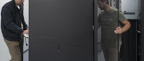 Technicians team updating hardware inspecting system performance in super computer server room or cryptocurrency mining farm. photo