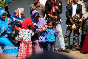 Dieng, Indonesia - August 1, 2015. Dieng Culture Festival, Tourists follow the dreadlocks procession during the Dieng Culture Festival event at Dieng, Banjarnegara district, Central Java photo