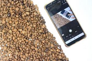 Coffee beans and a phone. Isolated on a white background. photo