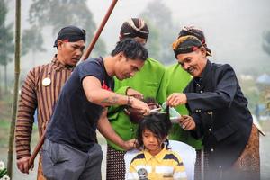 Dieng, Indonesia - August 1, 2015. Dieng Culture Festival, Tourists follow the dreadlocks procession during the Dieng Culture Festival event at Dieng, Banjarnegara district, Central Java photo