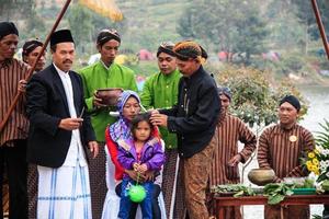 Dieng, Indonesia - August 1, 2015. Dieng Culture Festival, Tourists follow the dreadlocks procession during the Dieng Culture Festival event at Dieng, Banjarnegara district, Central Java photo