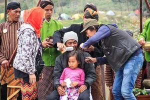 Dieng, Indonesia - August 1, 2015. Dieng Culture Festival, Tourists follow the dreadlocks procession during the Dieng Culture Festival event at Dieng, Banjarnegara district, Central Java photo