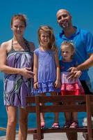 retrato de una joven familia feliz con hijas junto al mar foto