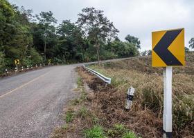 señal de dirección de la carretera asfaltada curva. foto