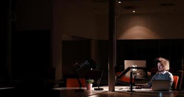 man working on computer in dark office photo