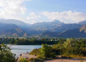 Calm scene at Lake Issyk Kul in Kyrgyzstan with mountains in the background photo