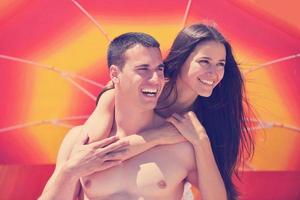 feliz pareja joven divertirse en la playa foto