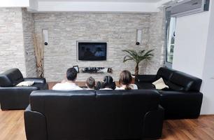 familia viendo televisión plana en casa moderna interior foto