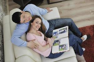 couple looking old pictures in photo album at home