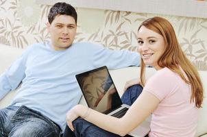 young couple working on laptop at home photo