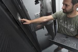 Technicians team updating hardware inspecting system performance in super computer server room or cryptocurrency mining farm. photo