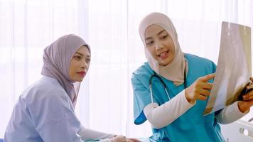 Muslim female doctor analysing disease to patient at hospital room. photo