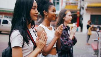 A group of multi-ethnic female friends praying at a Chinese shrine in Bangkok, Thailand. photo