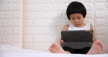 Cute little boy using tablet computer at home. photo