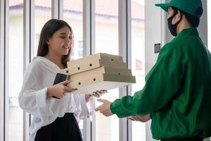 mujer feliz recibiendo comida del repartidor de alimentos foto